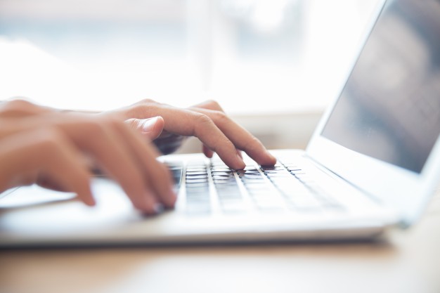 hands typing laptop